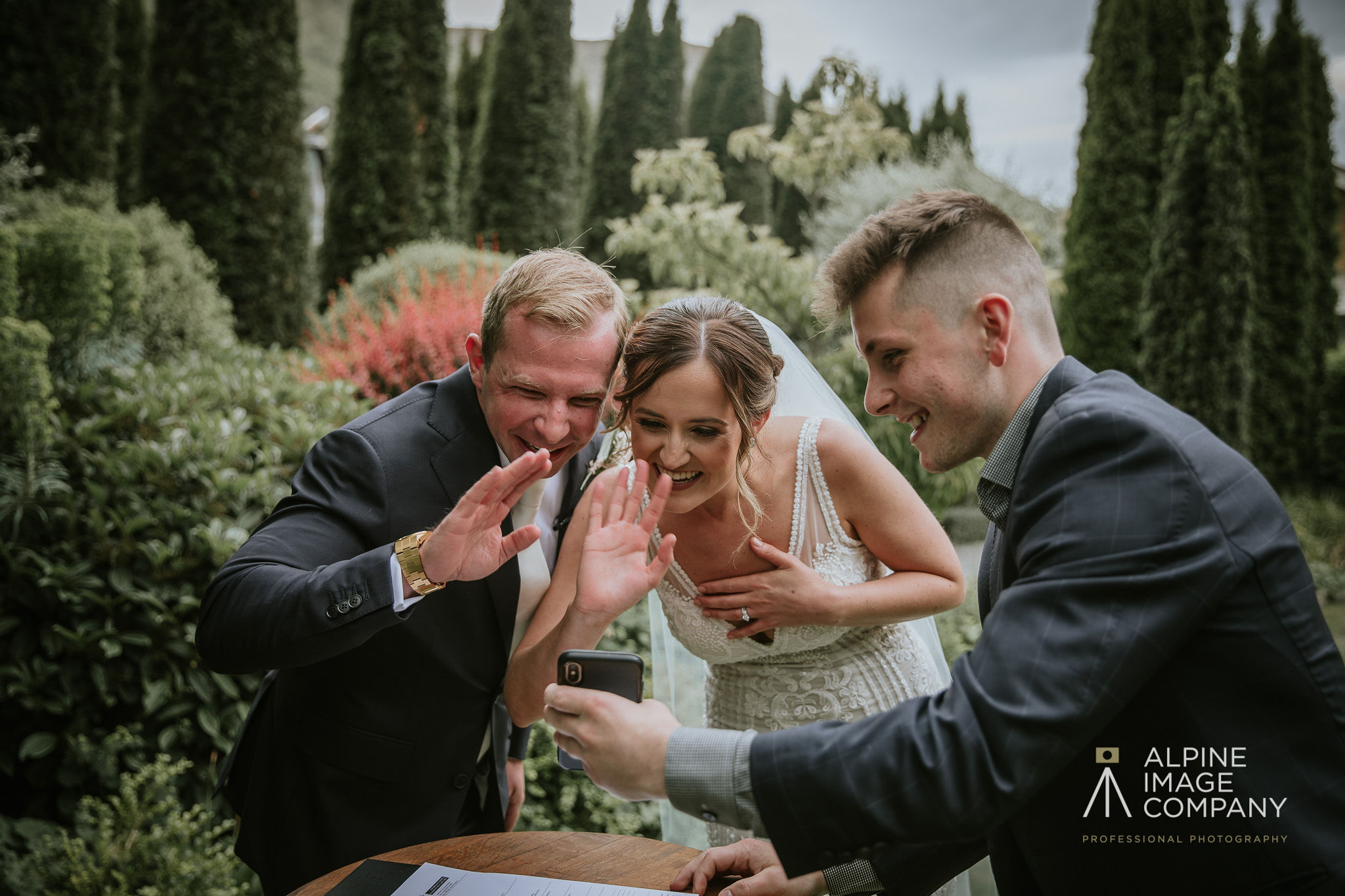 Bride and groom wave on a video call to missing family during wedding ceremony in Queenstown New Zealand