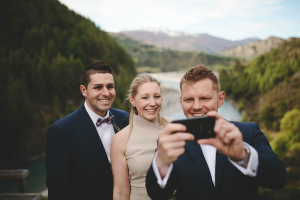gay couple take selfie with marriage celebrant in Queenstown, New Zealand