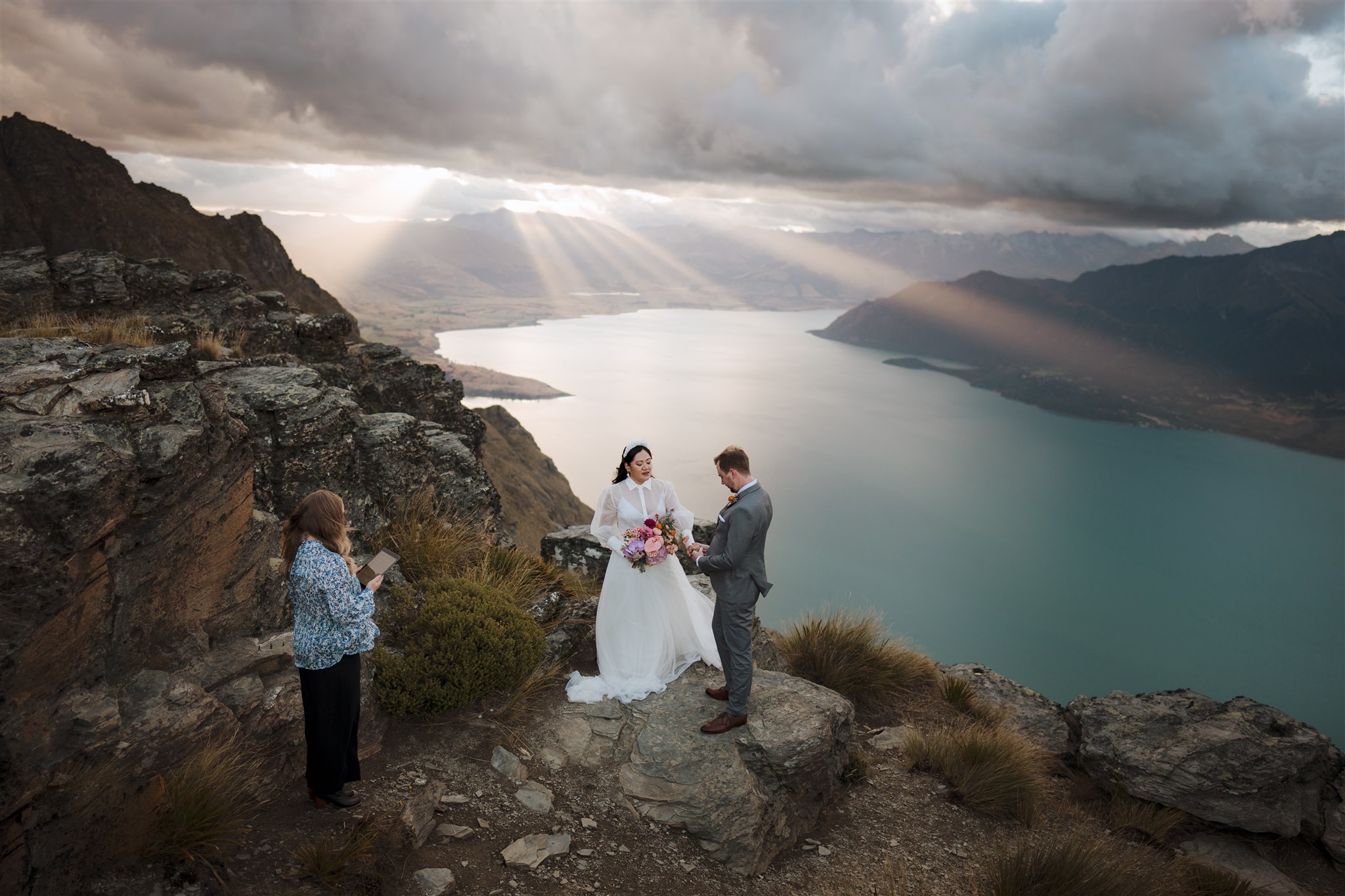 Queenstown wedding celebrant officiates wedding ceremony at Cecil Peak mountain top at sunset in Queenstown New Zealand