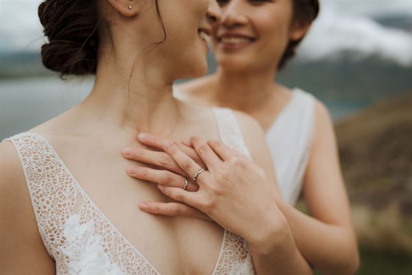 two brides show off their wedding rings after wedding in queenstown new zealand