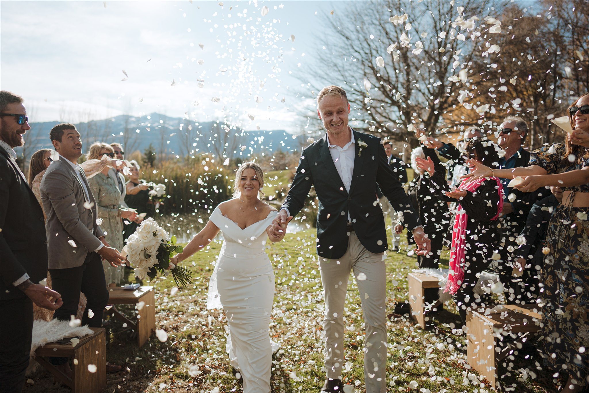 just married couple exit their ceremony with flower petal confetti from guests in Queenstown, New Zealand